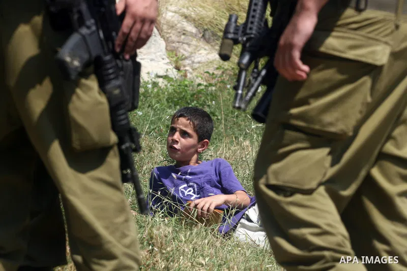 Israeli soldiers confront Palestinian child during a demonstration against Israel's separation barrier in the West Bank village of Nabi Saleh near Ramallah, Friday, June 29, 2012. Palestinians protest weekly against the...
