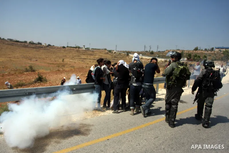Israeli soldiers fire a tear gas canister during clashes with Palestinian protester following a weekly demonstration against Israel's separation barrier and the neighbouring Jewish settlement of Halamish in the West Bank...
