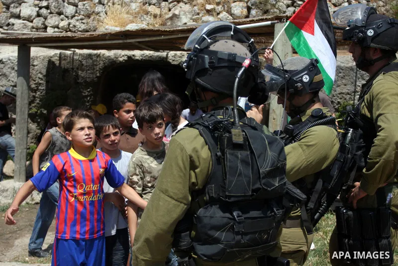 Israeli soldiers confront Palestinian children during a demonstration against Israel's separation barrier in the West Bank village of Nabi Saleh near Ramallah, Friday, June 29, 2012. Palestinians protest weekly against t...