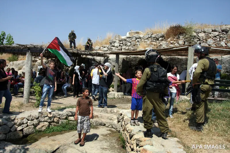 Israeli soldiers confront Palestinian children during a demonstration against Israel's separation barrier in the West Bank village of Nabi Saleh near Ramallah, Friday, June 29, 2012. Palestinians protest weekly against t...