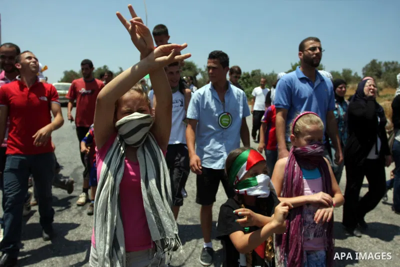 A Palestinian protestor raises the victory sign during a demonstration against Israel's separation barrier in the West Bank village of Nabi Saleh near Ramallah, , Friday, June 29, 2012. Palestinians protest weekly agains...