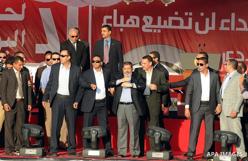 Egypt's president-elect Mohamed Morsi, surrounded by security guards, waves to protesters at the end of his speech at Tahrir square, in Cairo, Egypt, 29 June 2012. Media reports stated Morsi said on 29 June that people p...