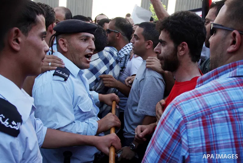 Palestinian police control the crowd in the West Bank city of Ramallah, on June 30, 2012, during a protest against a planned meeting between Palestinian leader Mahmud Abbas and Israel's vice prime minister Shaul Mofaz. T...