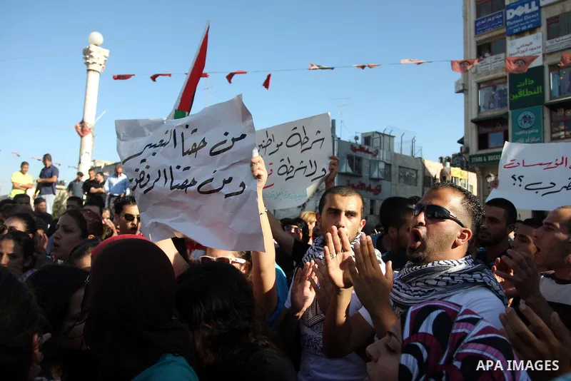 Palestinian protestors hold banners and national flags during a protest against a scheduled meeting between Palestinian President Mahmoud Abbas and the Israeli Vice Prime Minister Shaul Mofaz in the West Bank city of Ram...