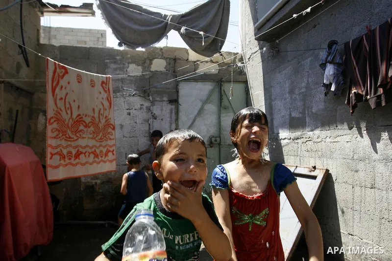 Palestinian children enjoy themselves with water during hot weather and high temperature in the southern Gaza Strip town of Rafah on July 02, 2012. Photo by Eyad Al Baba