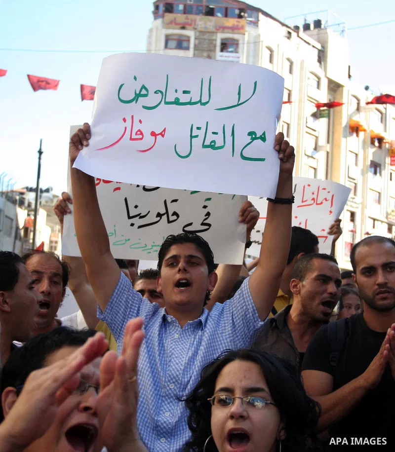 Palestinian demonstrators hold a national flag in the West Bank city of Ramallah on July 3, 2012 to protest against the violent dispersal of two similar rallies over the weekend. The demonstration was called by the "Pale...