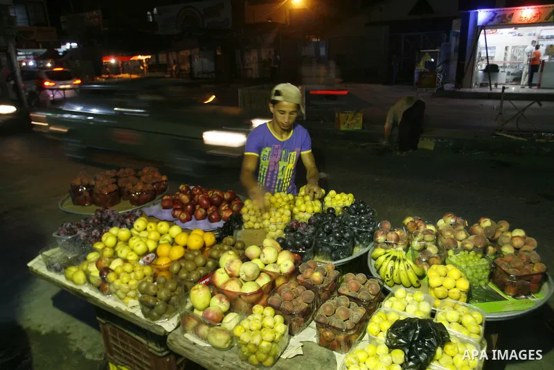 A Palestinian man sells fruits at a popular market in Rafah in southern Gaza on July 03, 2012. Photo by Eyad Al Baba