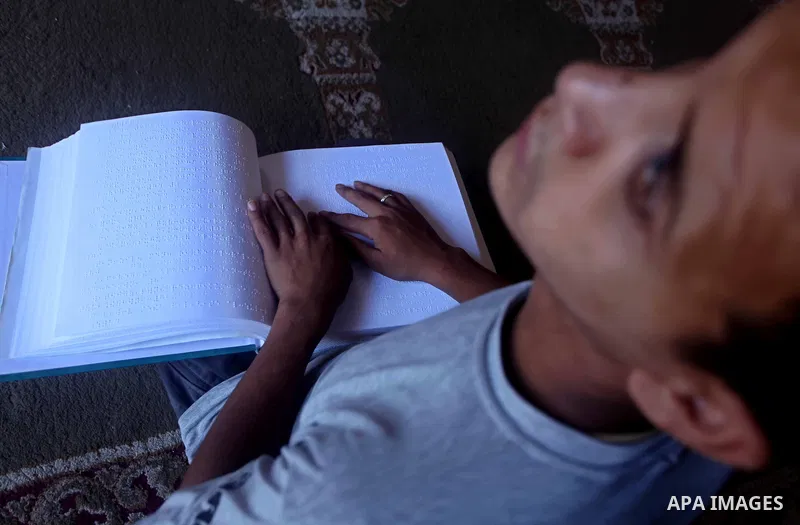 A blind Palestinian boy reads the Koran at a summer camp in the Gaza Strip, 04 July 2012. About 20,000 students, both male and female, study under the tuition of 1,200 teachers at the camp. Hamas usually isolates boys an...