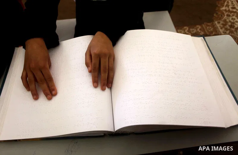 A blind Palestinian boy reads the Koran at a summer camp in the Gaza Strip, 04 July 2012. About 20,000 students, both male and female, study under the tuition of 1,200 teachers at the camp. Hamas usually isolates boys an...
