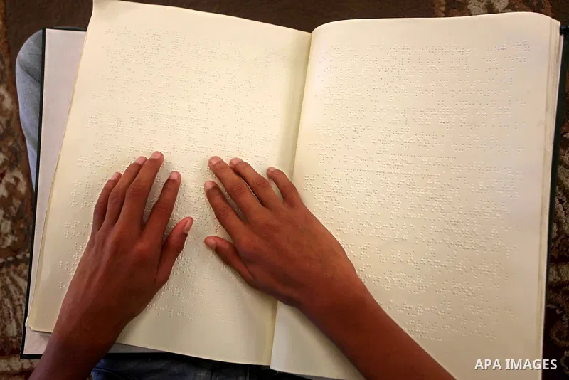 A blind Palestinian boy reads the Koran at a summer camp in the Gaza Strip, 04 July 2012. About 20,000 students, both male and female, study under the tuition of 1,200 teachers at the camp. Hamas usually isolates boys an...