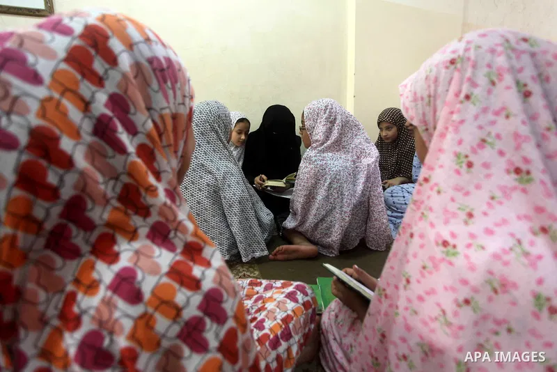 Palestinian girls read the Koran at a summer camp in the Gaza Strip, 04 July 2012. About 20,000 students, both male and female, study under the tuition of 1,200 teachers at the camp. Hamas usually isolates boys and girls...