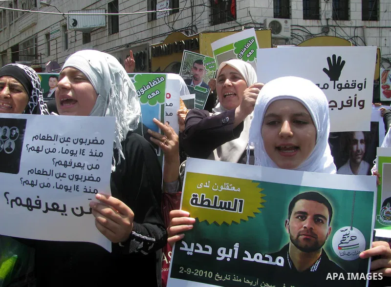 Palestinians hold national flags and pictures of political prisoners in the Palestinian Authority jails during a demonstration demands to release them, in the West Bank city of Ramallah, on 04 July 2012. Photo by Issam R...
