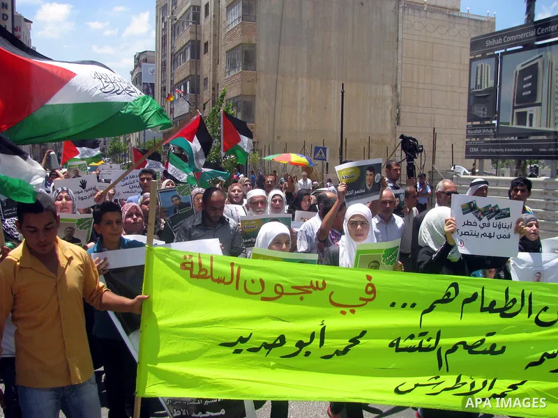 Palestinians hold national flags and pictures of political prisoners in the Palestinian Authority jails during a demonstration demands to release them, in the West Bank city of Ramallah, on 04 July 2012. Photo by Issam R...