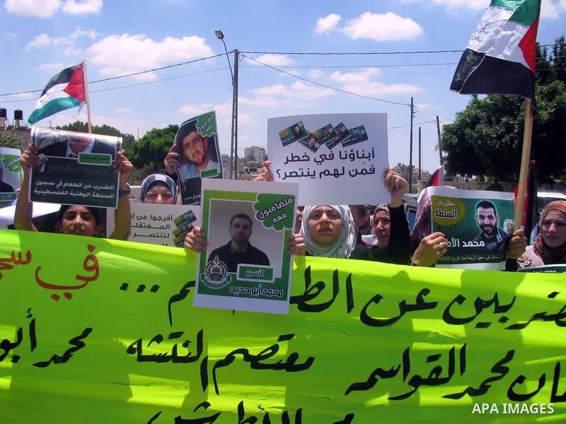 Palestinians hold national flags and pictures of political prisoners in the Palestinian Authority jails during a demonstration demands to release them, in the West Bank city of Ramallah, on 04 July 2012. Photo by Issam R...