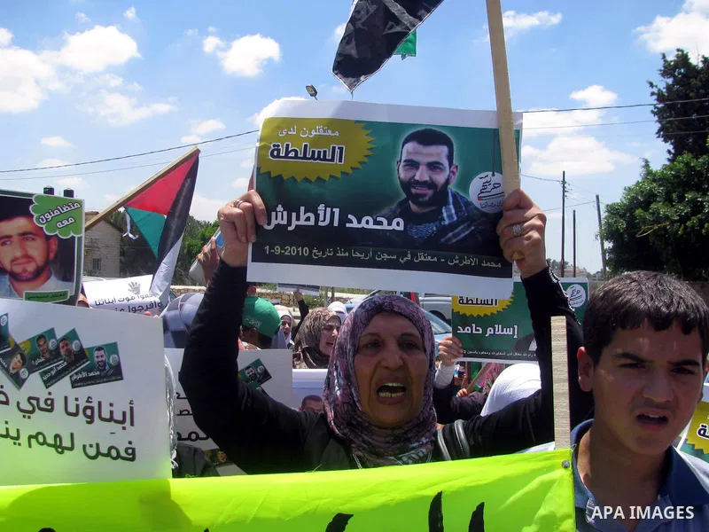 Palestinians hold national flags and pictures of political prisoners in the Palestinian Authority jails during a demonstration demands to release them, in the West Bank city of Ramallah, on 04 July 2012. Photo by Issam R...