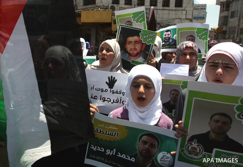 Palestinian supporters of the Islamic militant movement of Hamas, hold pictures of their relatives jailed at the Palestinian authority prisons as they protest close to president Mahmud Abbas' headquarters, in the West Ba...