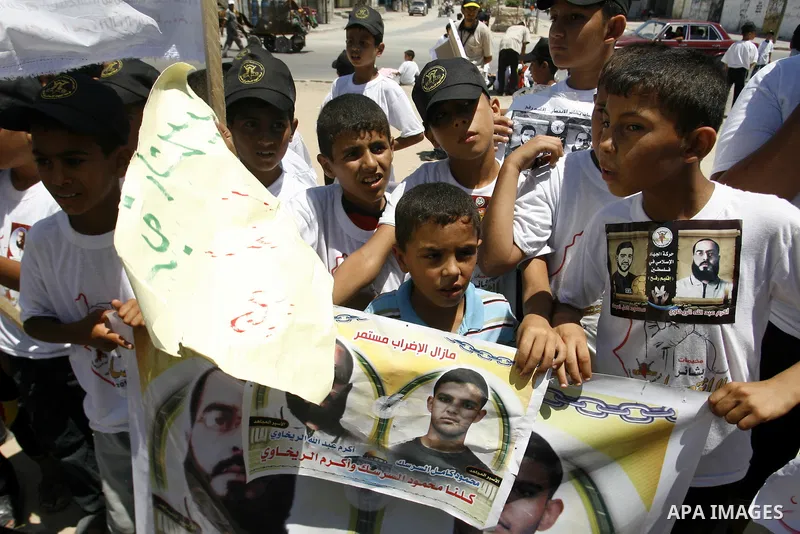 Palestinian boys hold pictures of Palestinian prisoners in the Palestinian Authority jails during a demonstration demands to release them, in the southern Gaza Strip town of Rafah on July 05, 2012. Photo by Eyad Al Baba