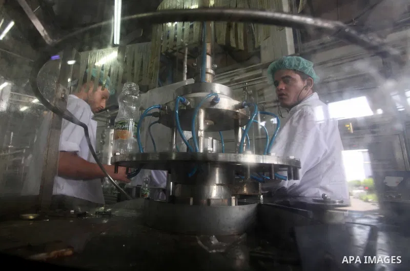 Palestinian workers bottle fruit juice at Juice Factory in Gaza City on July 5, 2011. it depends on citrus and fruit that are widely planted in Gaza Strip. Photo by Ashraf Amra