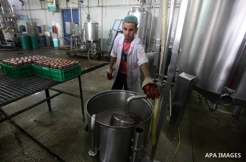 Palestinian workers bottle fruit juice at Juice Factory in Gaza City on July 5, 2011. it depends on citrus and fruit that are widely planted in Gaza Strip. Photo by Ashraf Amra