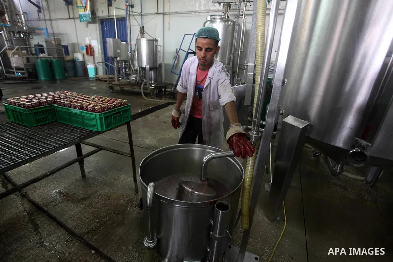 Palestinian workers bottle fruit juice at Juice Factory in Gaza City on July 5, 2011. it depends on citrus and fruit that are widely planted in Gaza Strip. Photo by Ashraf Amra