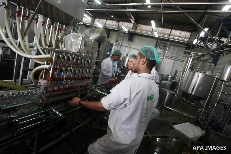 Palestinian workers bottle fruit juice at Juice Factory in Gaza City on July 5, 2011. it depends on citrus and fruit that are widely planted in Gaza Strip. Photo by Ashraf Amra
