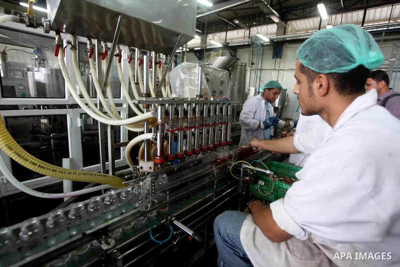 Palestinian workers bottle fruit juice at Juice Factory in Gaza City on July 5, 2011. it depends on citrus and fruit that are widely planted in Gaza Strip. Photo by Ashraf Amra