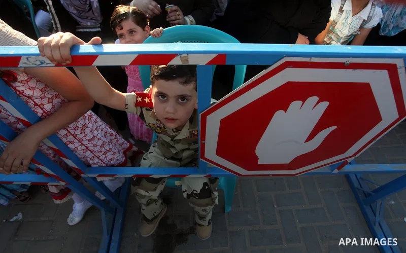 Palestinian child looks at graduating Hamas's police officers during a ceremony in Gaza City on July 05, 2012. Hamas has governed the Gaza Strip since June 2007, after it won a majority of seats in the Palestinian Parlia...