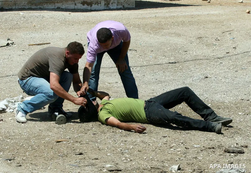 Palestinians help an injured man during clashes with Israeli border policemen following a protest against the expansion of the nearby Jewish settlement of Kdumim, in the northern West Bank village of Kufr Qaddum, on 06 J...