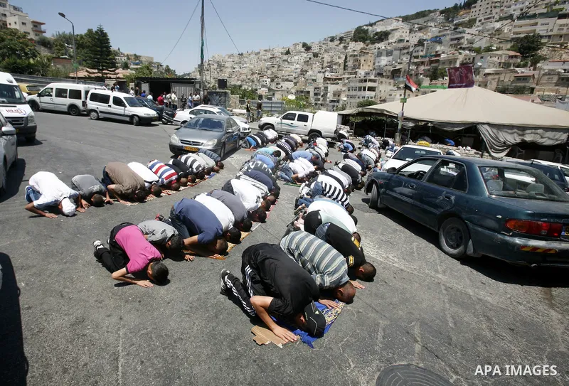 Palestinian Muslim worshippers attend Friday prayers outside a protest tent against the continuing 'Judaization of Jerusalem' by Jewish settlers, in the mostly Arab neighbourhood of Silwan in east Jerusalem on July 06, 2...
