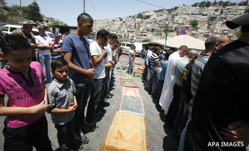 Palestinian Muslim worshippers attend Friday prayers outside a protest tent against the continuing 'Judaization of Jerusalem' by Jewish settlers, in the mostly Arab neighbourhood of Silwan in east Jerusalem on July 06, 2...