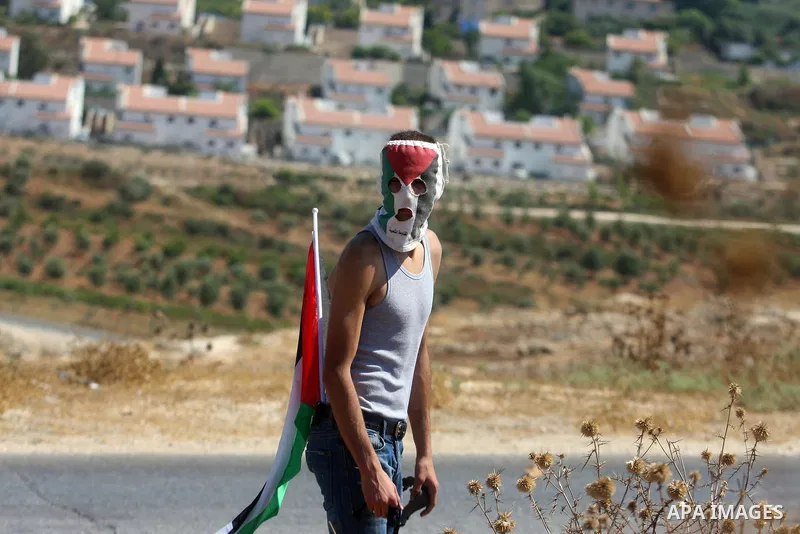 A Palestinian protester fires a stone from a slingshot towards Israeli soldiers during clashes at a weekly protest against a nearby Jewish settlement, in the West Bank village of Nabi Saleh, near Ramallah July 6, 2012. P...