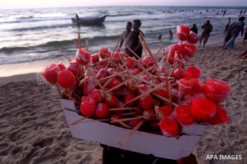 A Palestinian vendor sells the sweetness of apples on the beach in the Mediterranean port of Gaza on June 29, 2012. Photo by Ashraf Amra