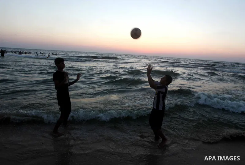 Palestinian children paly foot ball on their week-end in the Mediterranean sea in Gaza City on July 06, 2012. Photo by Ashraf Amra