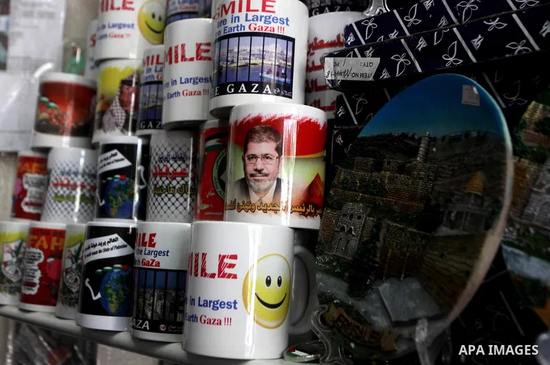 Palestinian vendor displays merchandise with pictures of the late Palestinian leader Yasser Arafat in Gaza City on July 7, 2012. Arafat, who died in 2004, was poisoned by polonium, according to the findings of laboratory...