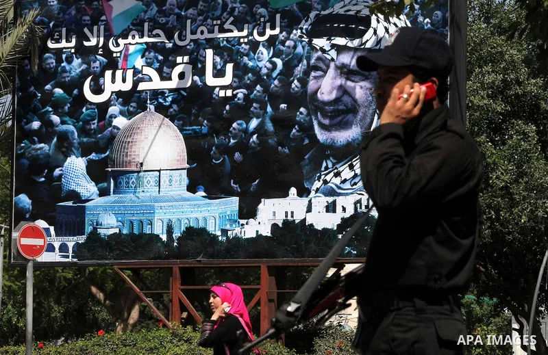 Palestinian police stands next to a huge poster of late Palestinian leader Yasser Arafat in Gaza City on July 7, 2012. The Palestinian National Authority (PNA) has agreed to exhume late President Yasser Arafat's body for...