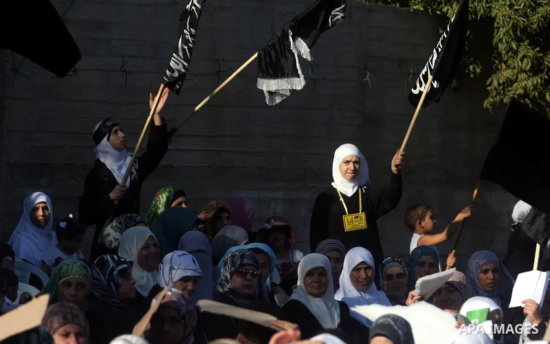 Palestinian supporters of Hizb ut-Tahrir or the Islamic Liberation Party, chant slogans and wave black and white flags with the religous writing "There is no God but God, and Mohammed is his prophet" during a rally in th...