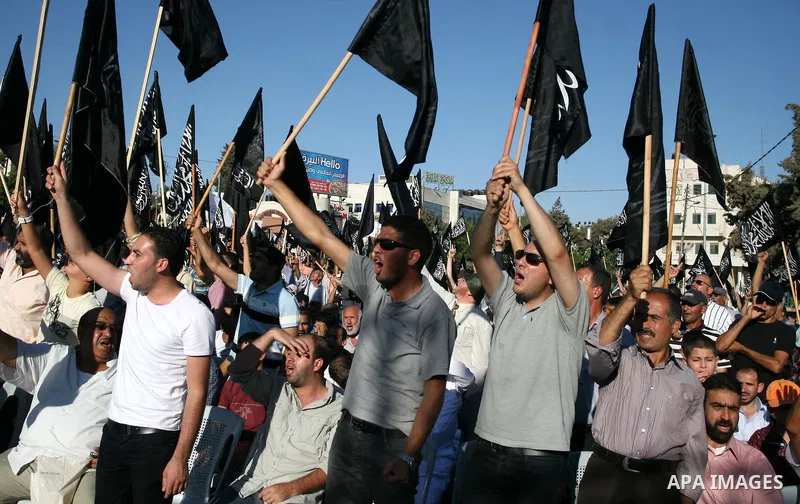 Palestinian supporters of Hizb ut-Tahrir or the Islamic Liberation Party, chant slogans and wave black and white flags with the religous writing "There is no God but God, and Mohammed is his prophet" during a rally in th...