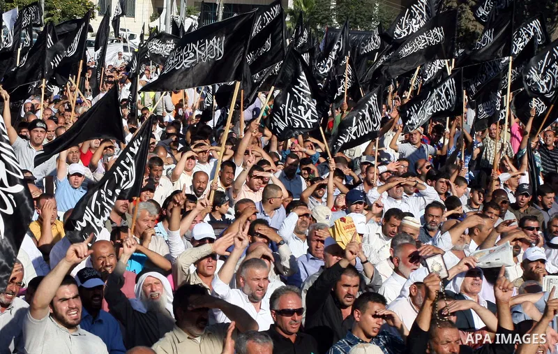 Palestinian supporters of Hizb ut-Tahrir or the Islamic Liberation Party, chant slogans and wave black and white flags with the religous writing "There is no God but God, and Mohammed is his prophet" during a rally in th...