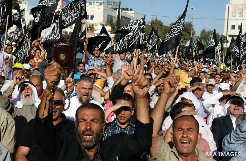 Palestinian supporters of Hizb ut-Tahrir or the Islamic Liberation Party, chant slogans and wave black and white flags with the religous writing "There is no God but God, and Mohammed is his prophet" during a rally in th...