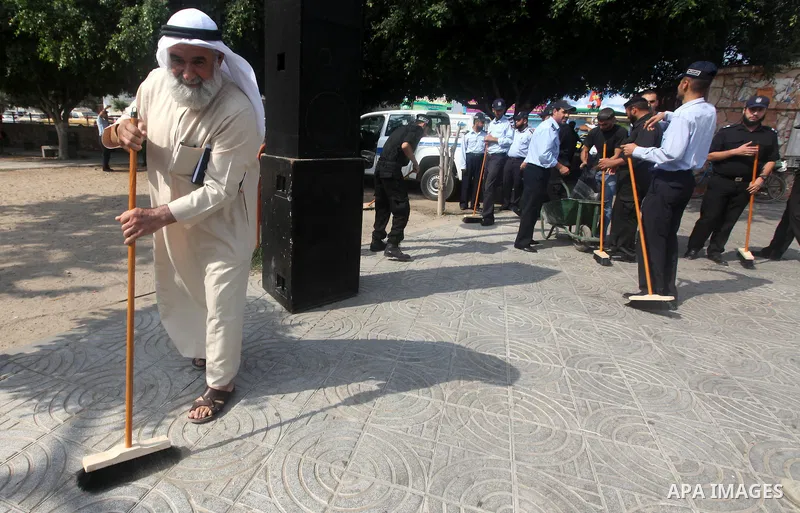 Palestinian officers participate in cleaning streets during a campaign organized by ministry of Labor, in Gaza city on July 09 2012. Photo by Majdi Fathi