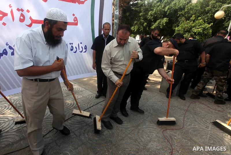 Palestinian officers participate in cleaning streets during a campaign organized by ministry of Labor, in Gaza city on July 09 2012. Photo by Majdi Fathi