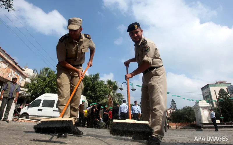 Palestinian officers participate in cleaning streets during a campaign organized by ministry of Labor, in Gaza city on July 09 2012. Photo by Majdi Fathi