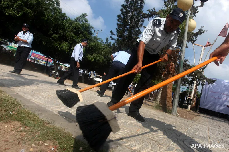 Palestinian officers participate in cleaning streets during a campaign organized by ministry of Labor, in Gaza city on July 09 2012. Photo by Majdi Fathi