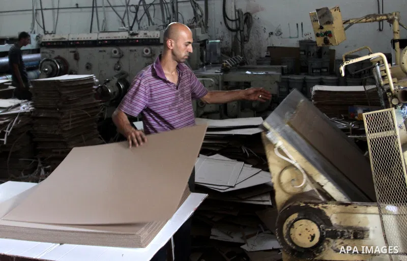 Palestinian labourers work at a factory for making a carton in the West Bank city of Nablus on July 09, 2012. Photo by Nedal Eshtayah