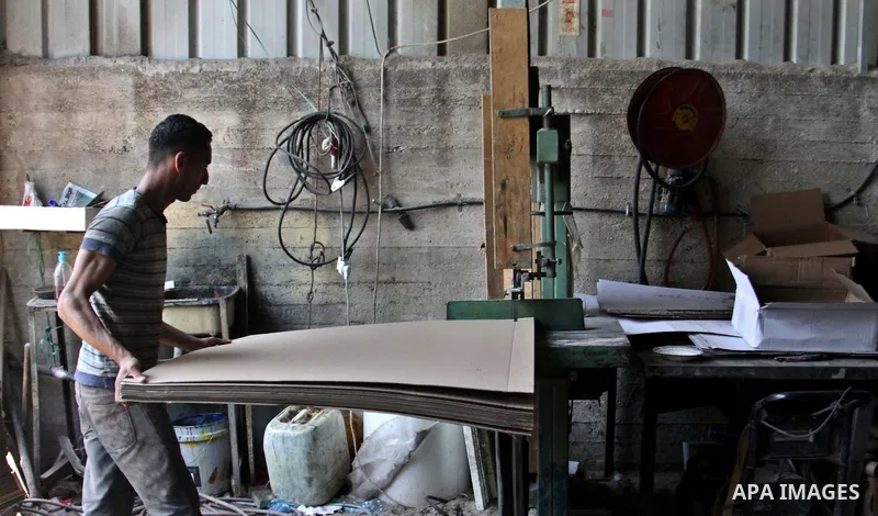 Palestinian labourers work at a factory for making a carton in the West Bank city of Nablus on July 09, 2012. Photo by Nedal Eshtayah
