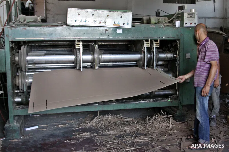 Palestinian labourers work at a factory for making a carton in the West Bank city of Nablus on July 09, 2012. Photo by Nedal Eshtayah