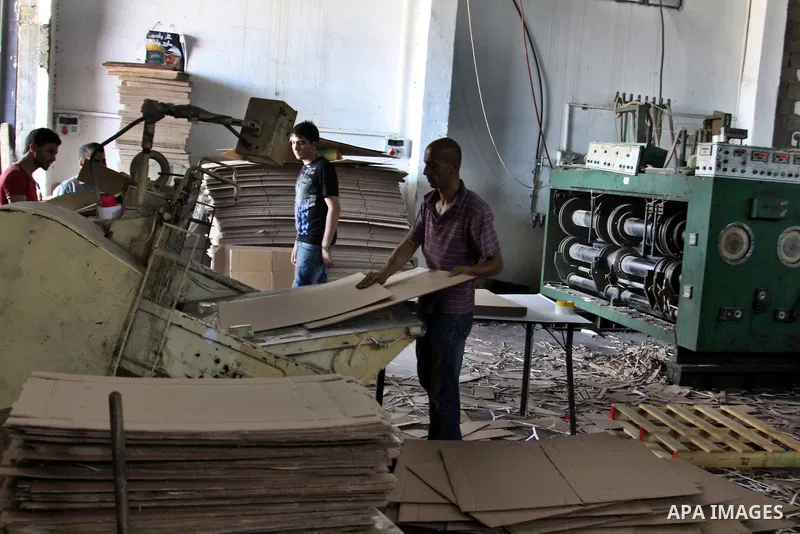 Palestinian labourers work at a factory for making a carton in the West Bank city of Nablus on July 09, 2012. Photo by Nedal Eshtayah