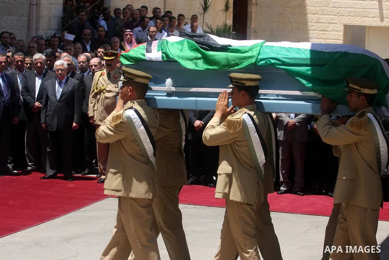Palestinian President Mahmud Abbas attends the funeral of Hani al-Hassan, who was a close aide of Palestinian late leader, Yasser Arafat, as soldiers carry his coffin during his funeral procession in the West Bank city o...