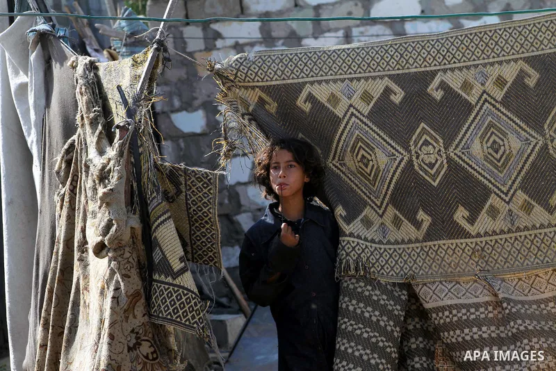 A Palestinian child looks through a mat of straw in front her home in Zeitoun neighborhood southern Gaza city on 09 July 2012. Photo by Ashraf Amra