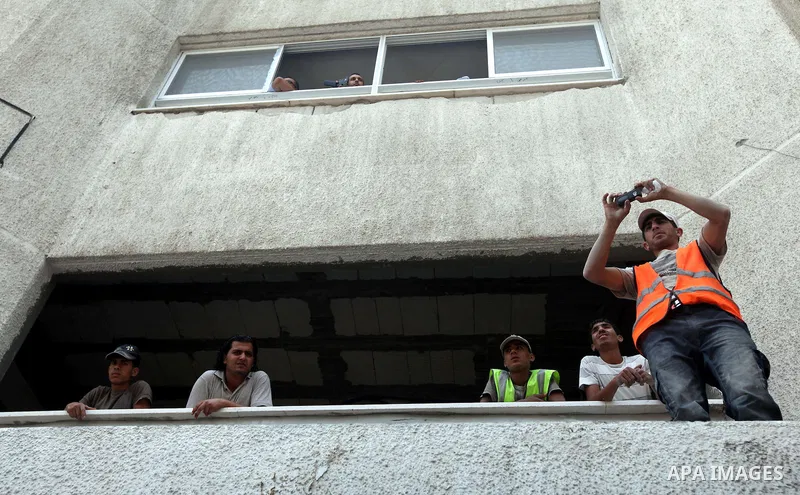 Palestinians look at soccer player Mahmoud Al-Sarsak while he waves to people upon his arrival in Gaza City July 10, 2012. Israel released the Gaza soccer player on Tuesday in a deal to end his intermittent four-month hu...